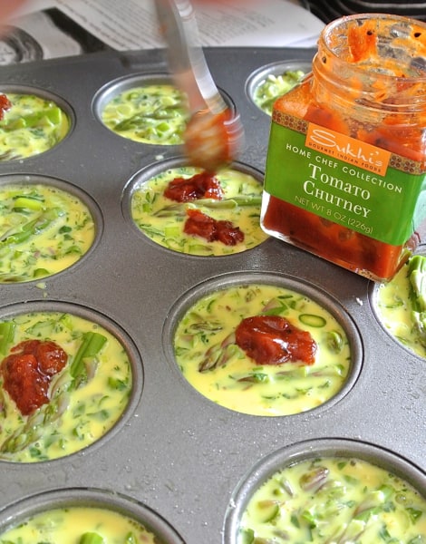 raw quiche muffins with tomato chutney ready to be baked