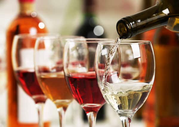 Wine glasses lined up and wine being poured in one of the glasses