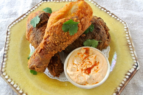indian fried chicken drumsticks stacked on yellow plate