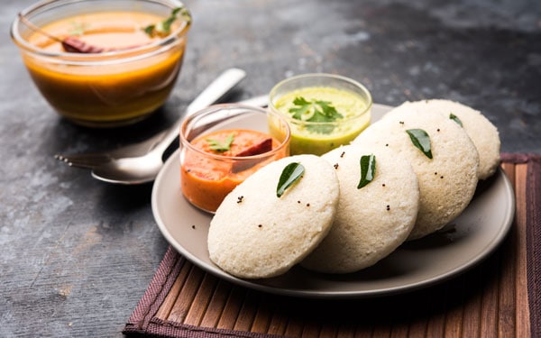 Idli served on a plate with chutney and sambhar