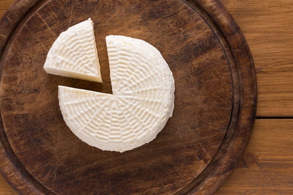 Homemade Paneer on a wooden board.