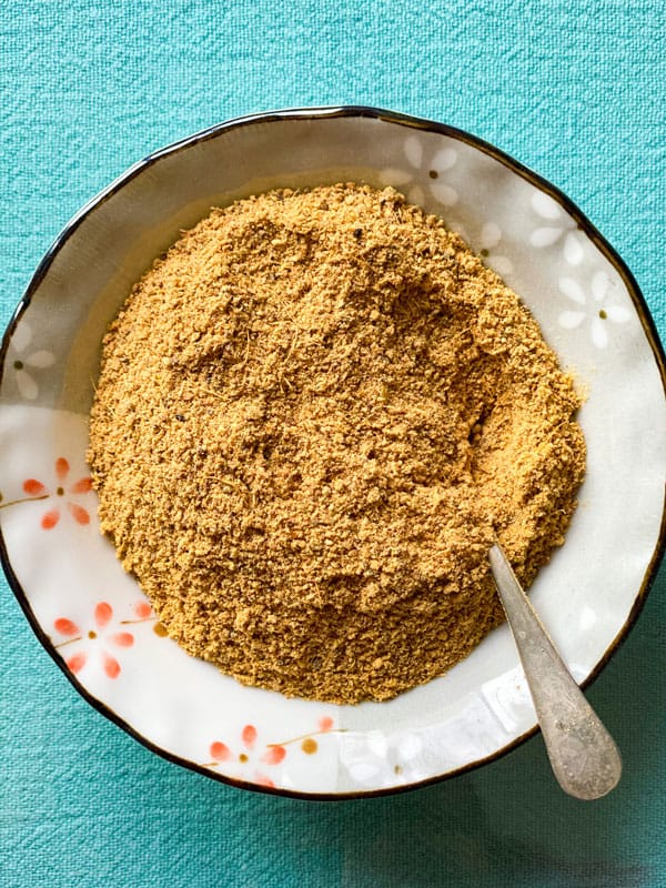 Chai Masala powder in a bowl with spoon