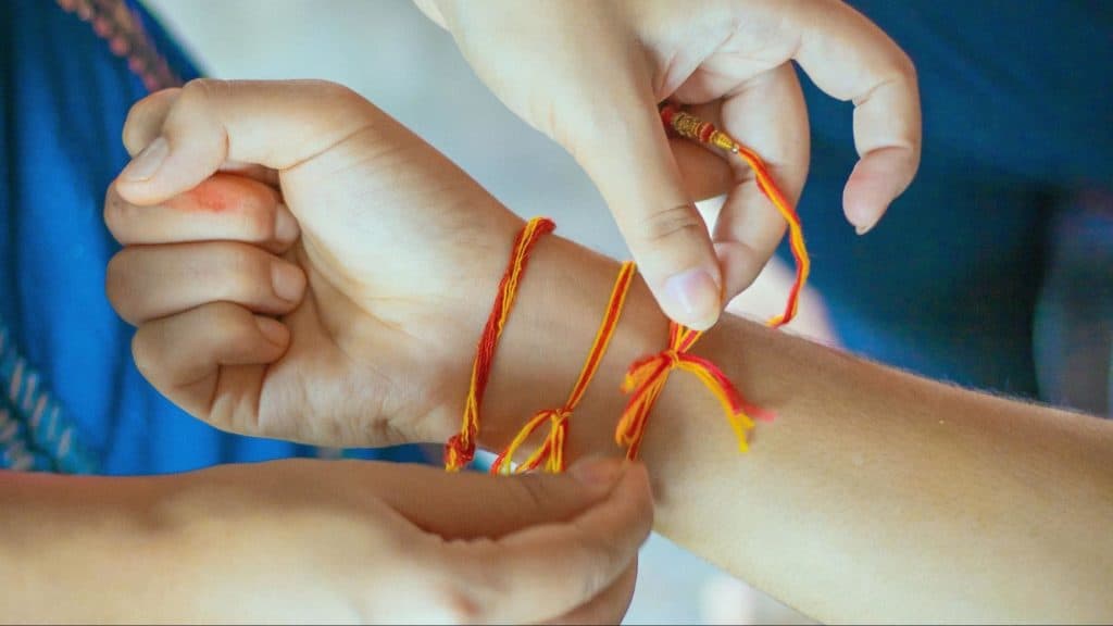 Children tying rakhi on wrists